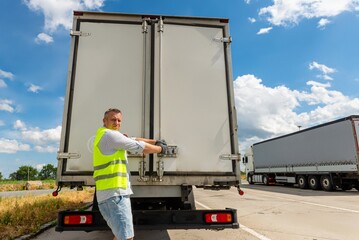 Worker opening the rear doors of a delivery truck © Aliaksandr