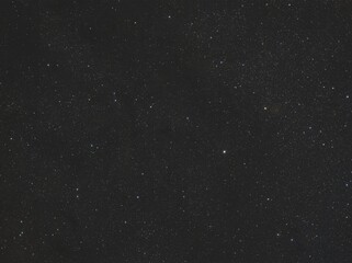 Fototapeta premium Vast dark night sky is visible, densely packed with myriad white and subtly colored stars. This cosmic view showcases celestial bodies in the depths of space at night.
