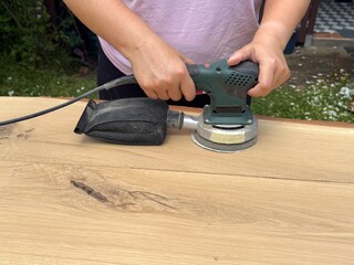 Carpenter Sanding Wooden Table in Workshop © Jenny Sturm
