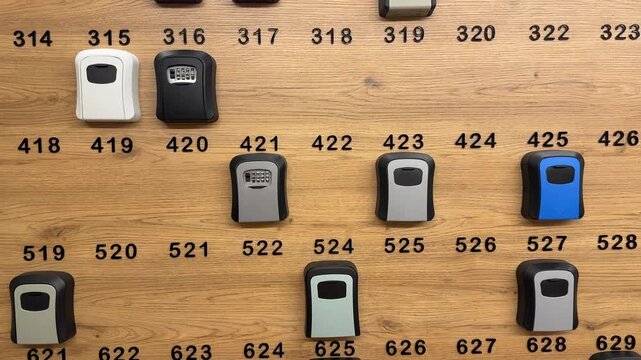 Row of combination lock boxes on a wooden wall display for secure key storage options
