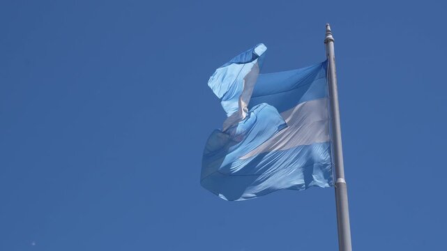 National flag of argentina waving in the wind on a flagpole. Argentinian symbol with blue and white stripes and the sun of may