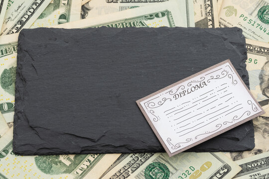 Blank chalkboard with diploma on twenty dollar bills for the cost of education