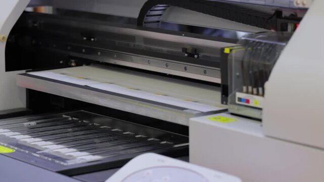 Industrial uv flatbed printer head moving across printing surface.