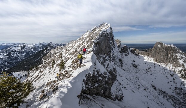 Two mountaineers on a narrow snowy rocky ridge, Fensterl on the hiking trail to Ammergauer Hochplatte, in autumn, Ammergau Alps, Bavaria, Germany