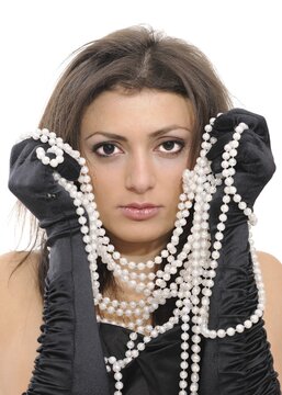 Young woman in a black dress, black gloves and a long string of pearls