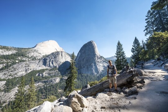 Hiker on trail to Glacier Point, Outlook on Liberty Cap, Mt. Broderick and Half Dome, Yosemite National Park, California, USA