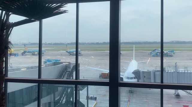 Tan Son Nhat Airport Terminal 3 window view of airplanes and runway.
