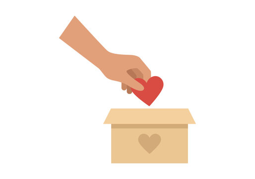 Mano depositando un coraz&oacute;n rojo dentro de una caja de cart&oacute;n
