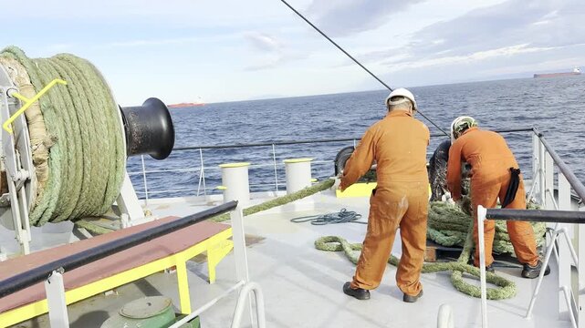 after sea passage seafarers prepare ropes for mooring at port.