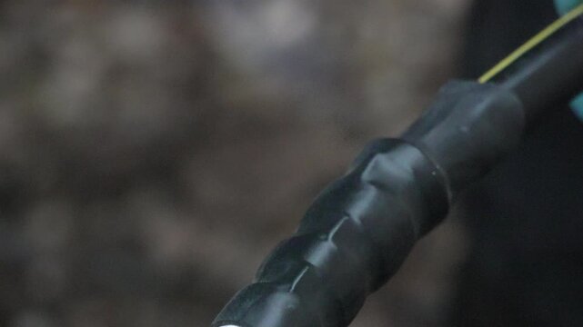 Cable insulation terminal, applying black heat shrink tubing to a thick electrical wire connector during industrial repair process.