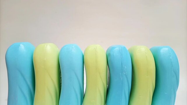 Soap bar. blue and yellow soap bars for bath in a row moving on white background. aromatic soap for body and face. pieces of blue and yellow bathing soap,