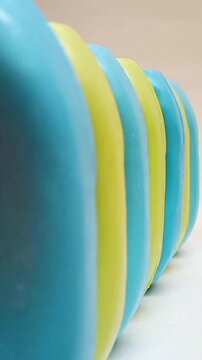 Soap bar. blue and yellow soap bars for bath in a row rotating on white background. aromatic soap for body and face. pieces of blue and yellow bathing soap, vertical clip