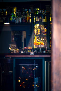 Stimmungsvoll beleuchtete Bar mit gut sortiertem Spirituosenregal im Vintage-Stil