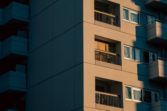 Apartment building facade with balconies in warm shadow light