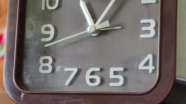 Macro shot of an analog clock face with the second hand moving at an accelerated speed. This timelapse effect visualizes concepts of rushing deadlines and time running out.