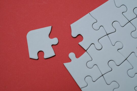 Missing puzzle piece on a red background. Concept for business solution, problem solving, teamwork, strategy, and final touch to achieve success