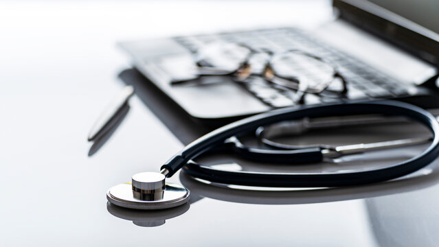 Healthcare background of stethoscope laptop glasses and pen on table with copy-space