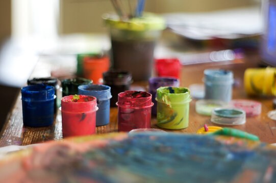 Artistic workspace with colorful palette and gouache paint on a table
