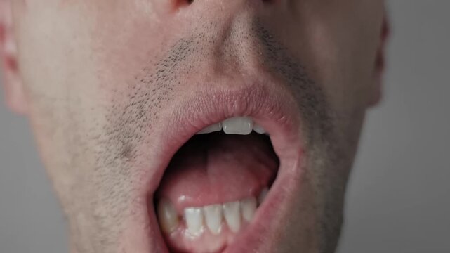 Macro shot shows an unshaven male mouth pulling down the lower lip for inspection. The dental check examines teeth and gums for health or pain in a medical concept.