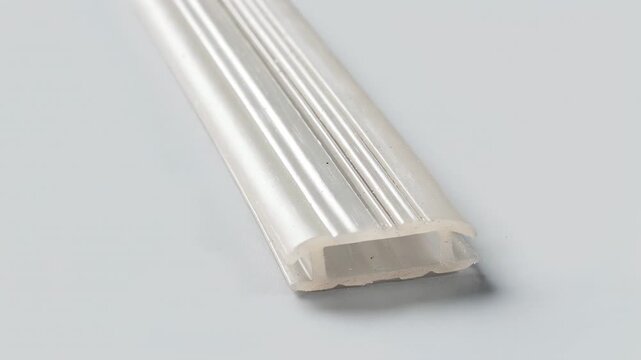Closeup medium shot of a coextruded profile showcasing an elegant decorative strip contrasting soft and hard plastic segments for design versatility.