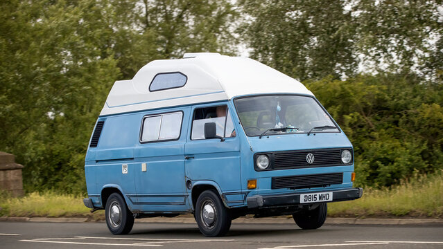 Stony Stratford,Bucks,UK - June 7th 2026:  1987 blue Volkswagen Transporter camper van car driving on a British road