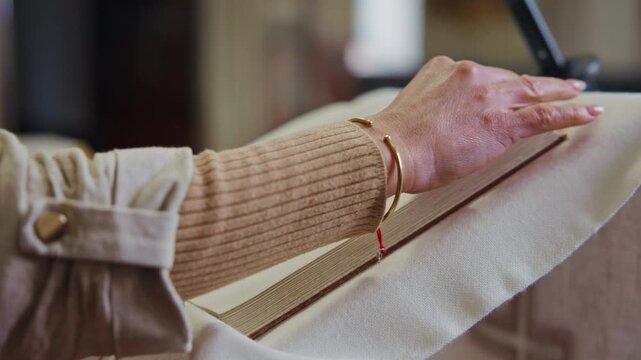 Female hands turning the pages of the scripture placed on a pulpit, during Catholic Mass. Woman in religious tradition concept.