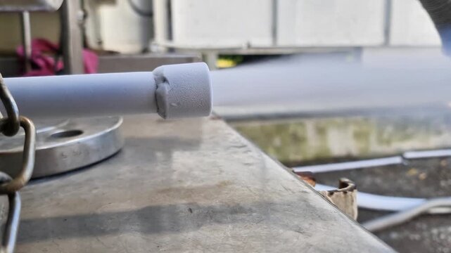 Cryogenic liquid nitrogen gas releasing from a metal venturi injector nozzle in a laboratory or industrial setting