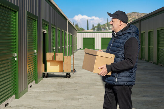 Self storage facility, man moving cardboard boxes into rental storage unit at warehouse complex, customer using self service storage for relocation and logistics