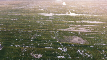 Obraz premium Morning frost on wet agricultural meadow surface