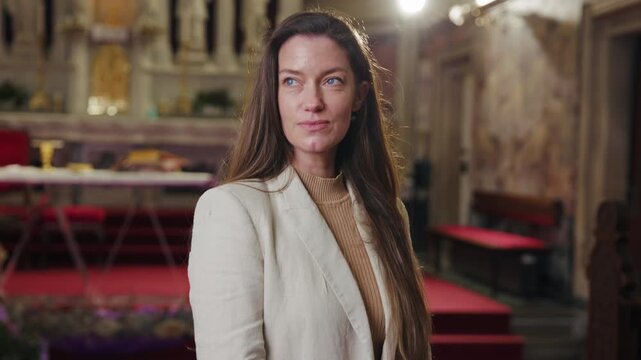 Portrait of a beautiful smiling woman, a lay minister in the Catholic Church, standing in front of the altar, in a peaceful religious setting.