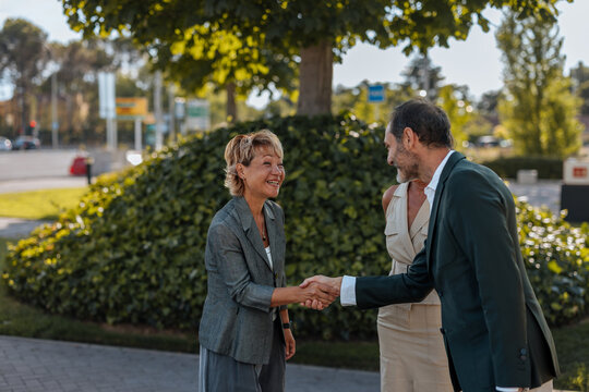 Business people shaking hands making agreement outdoors