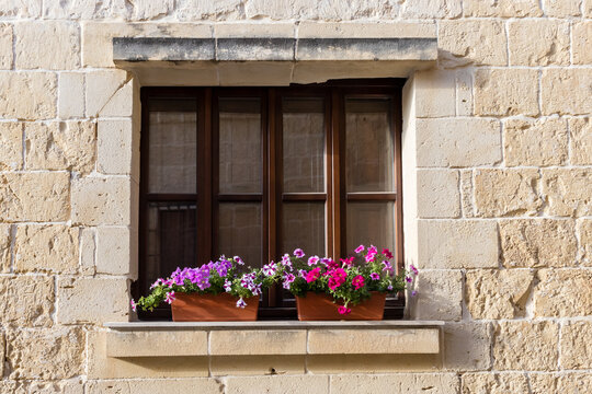 Sunlit Stone Building, Wooden Window With Colorful Flower Boxes On Mediterranean Facade