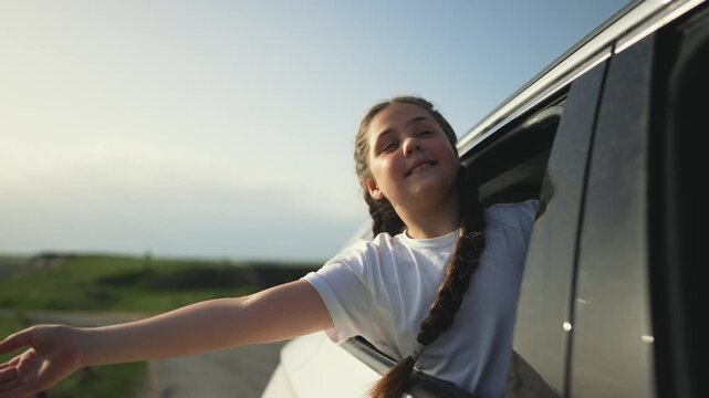 Teenager enjoying vacation concept. Teenager with stretches hand out car window. Happy teenager during vacation trip. travel moment. Carefree teenager enjoying vacation. vacation concept for girl.