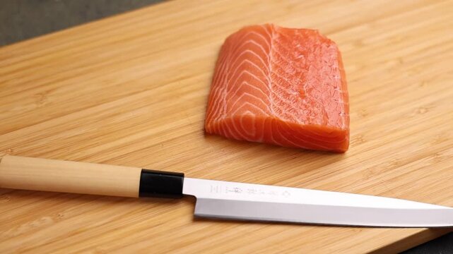 Close-up of a chef slicing fresh salmon on a wooden cutting board. Sharp knife, detailed texture of raw fish, and professional kitchen atmosphere emphasize precision, freshness, and gourmet culinary p
