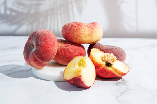 Pile of organic fig peaches with vibrant colors on a white background.