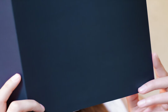 Dettaglio ravvicinato di donna che legge una brochure in atmosfera soft e rilassata