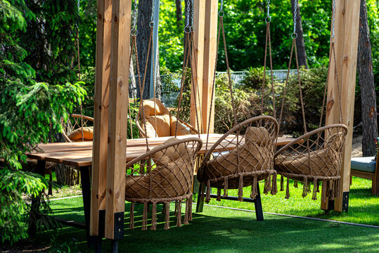 Outdoor garden dining area with hanging wicker chairs