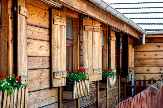 Wooden house facade with traditional shutters and flower boxes