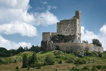 Fototapeta premium Mirow Castle on a limestone hill in Poland, a historic stone landmark surrounded by green countryside and summer clouds