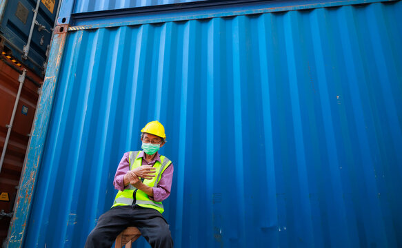 people holding hand painful inflammation, wrist tendonitis. Tired asian senior male container worker in protective face mask, hardhat helmet and uniform