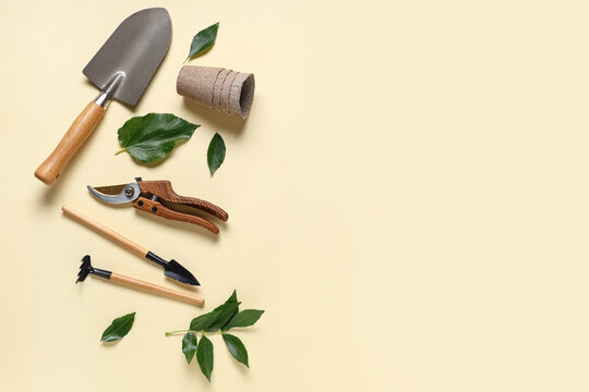 Gardening tools with shovel, pruner and peat pot on beige background. Top view