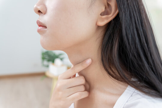 Asian woman put on neck due to a sore throat. female tonsillitis causes a inflammation. treated by taking water, taking antibiotics, consult a doctor, virus, corona virus, Influenza, flu
