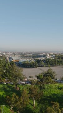 Aerial footage of large empty car park and sports arena. Famous Dodger Stadium at golden hour. Los Angeles, California, USA