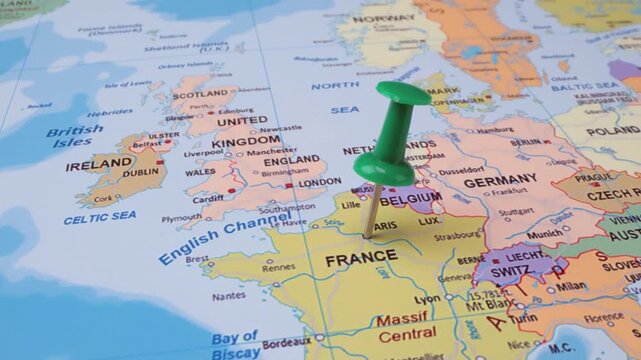 Green pushpin marking location on Europe map, France and Belgium highlighted, travel destination concept.
