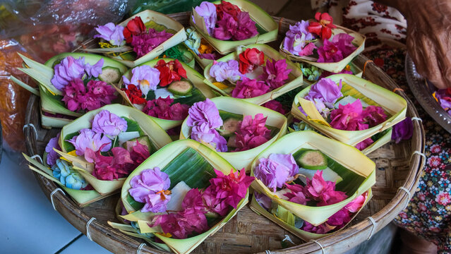 Multiple Balinese Canang Sari Traditional Flower Offerings Arranged on a Woven Bamboo Tray