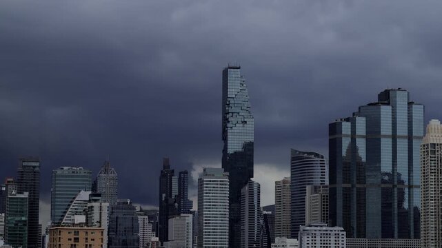 Fast-moving rain clouds create a moody atmosphere above pixel-art skyscrapers. skyscrapers of Bangkok. Thailand.