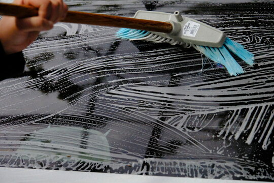 washing car windows with a brush
