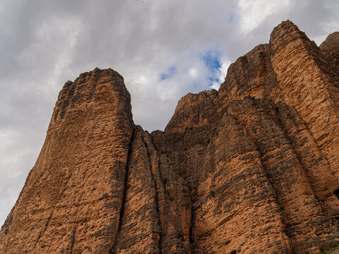 Mallos de riglos rock formations towering under cloudy sky