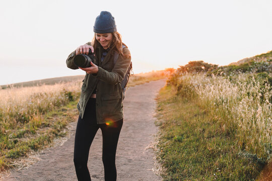 photographer Woman Holding Camera Outdoors sunset on trail 