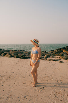 Woman in striped bikini standing on the beach
